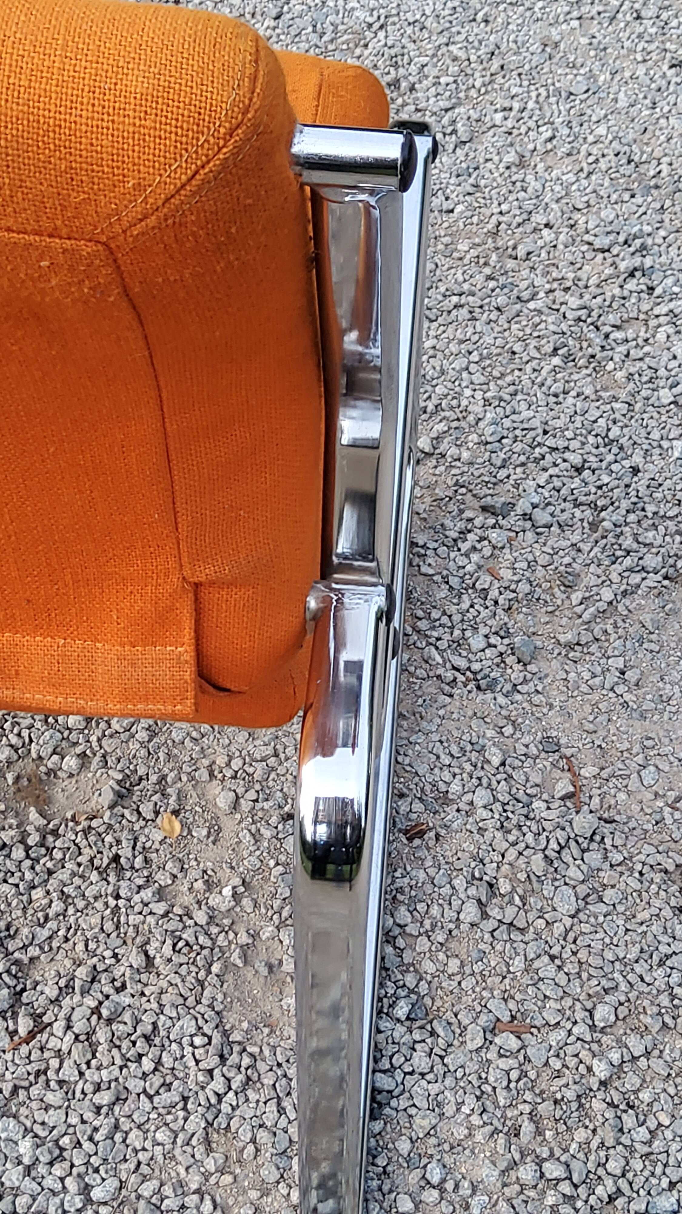 Pair of designer armchairs in orange fabrics and chrome tubes from the 70s