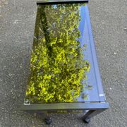 Vintage 1970s rolling bar cart made of metal and smoked glass.