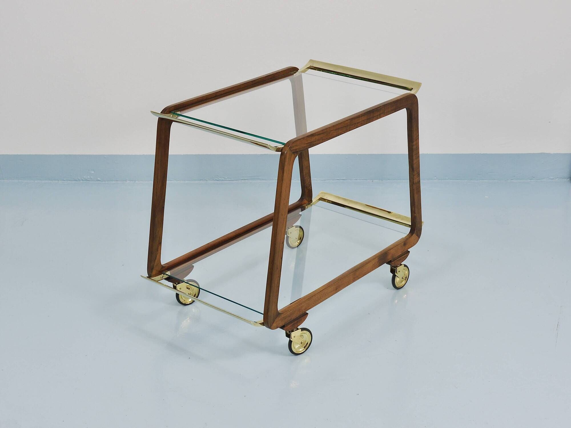 May include: A mid-century modern bar cart with a dark wood frame and two c