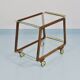 May include: A mid-century modern bar cart with a dark wood frame and two c