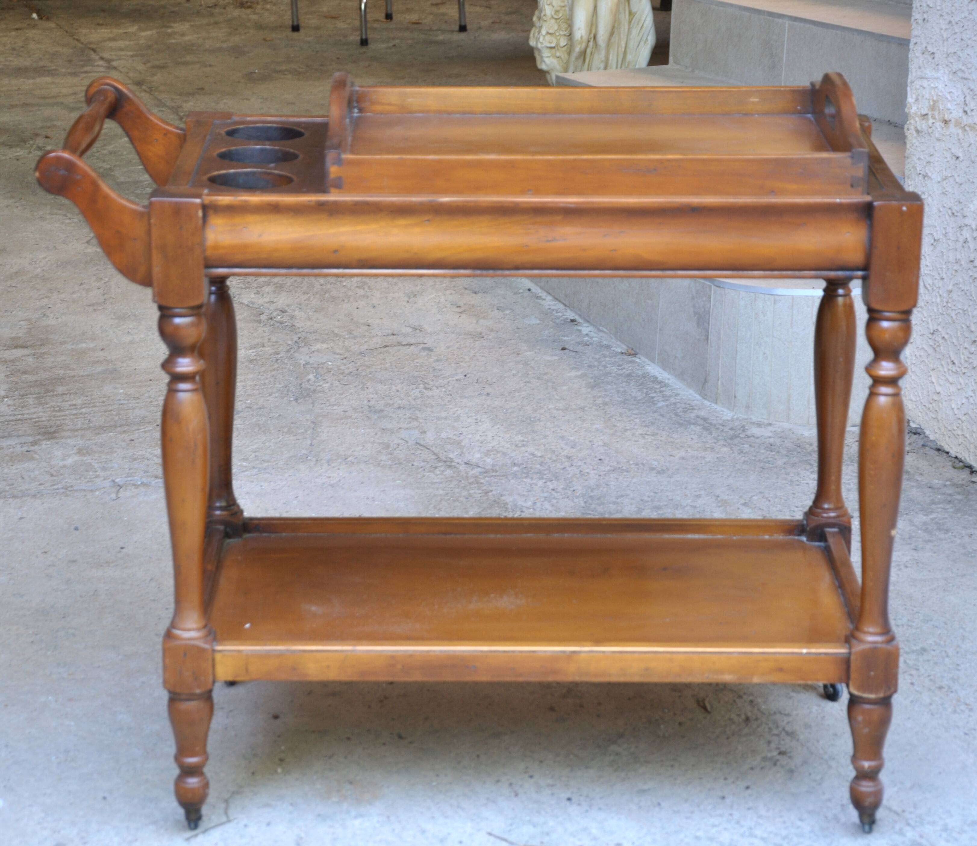 Serving table with a tray, on wheels, made of solid exotic wood.