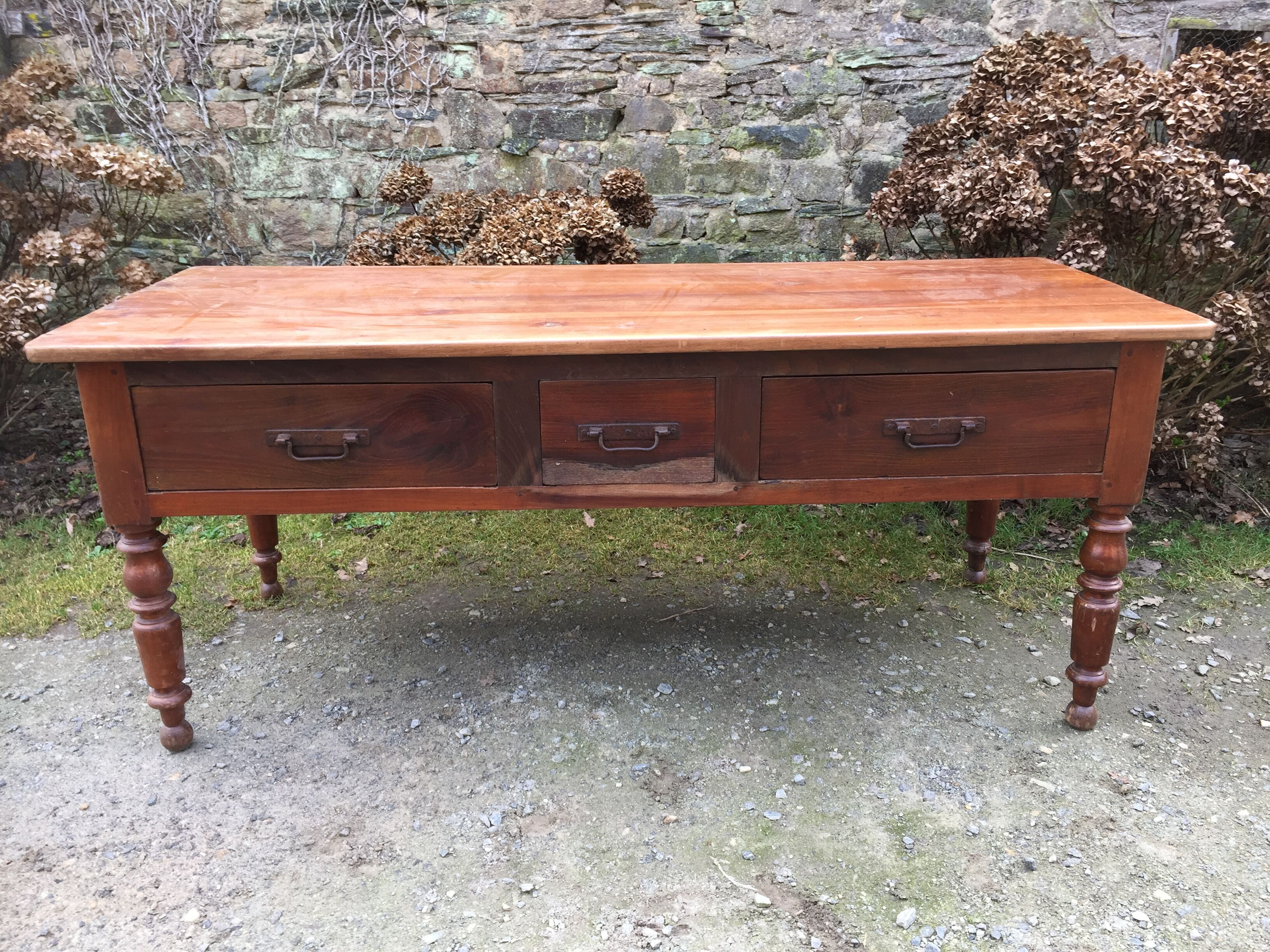 Old farmhouse table with cherry and chestnut panels with 3 drawers.