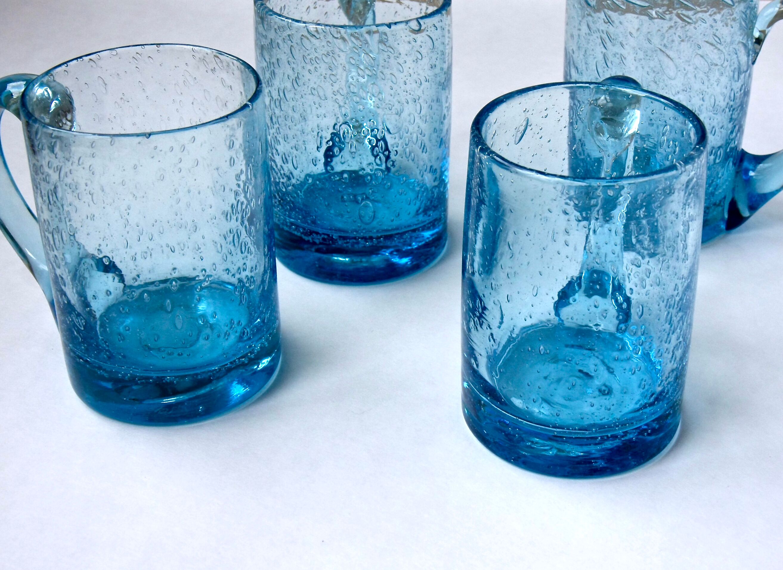 Four Biot glass mugs blue bubbled glass