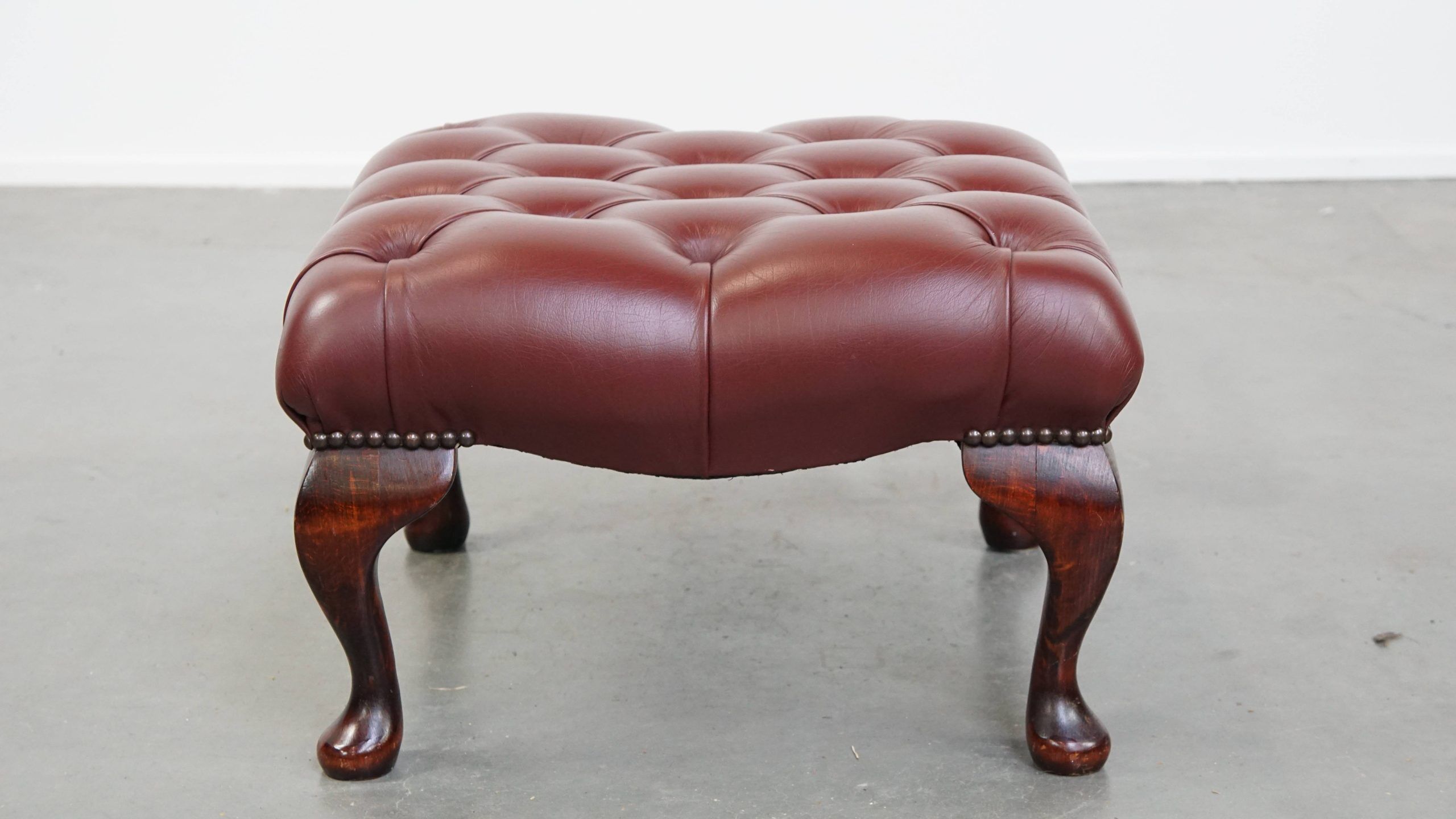 In very good condition elegant red/brown chesterfield ottoman made of cow leather
