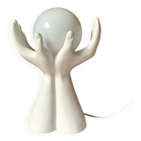 Ceramic table lamp depicting two hands holding a globe, 1980