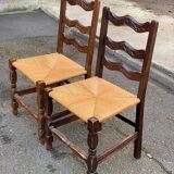 2 solid wood chairs with carved rush seats