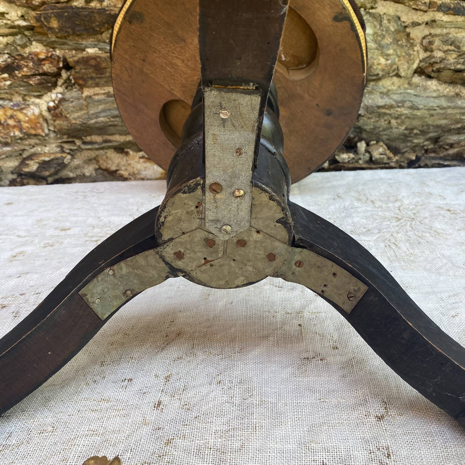 Old adjustable piano stool, blackened wood, metal screws, embroidered seat.