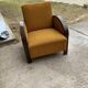 Art Deco armchair from the 1920s in straw yellow fabric and dark wood, with curved armrests.