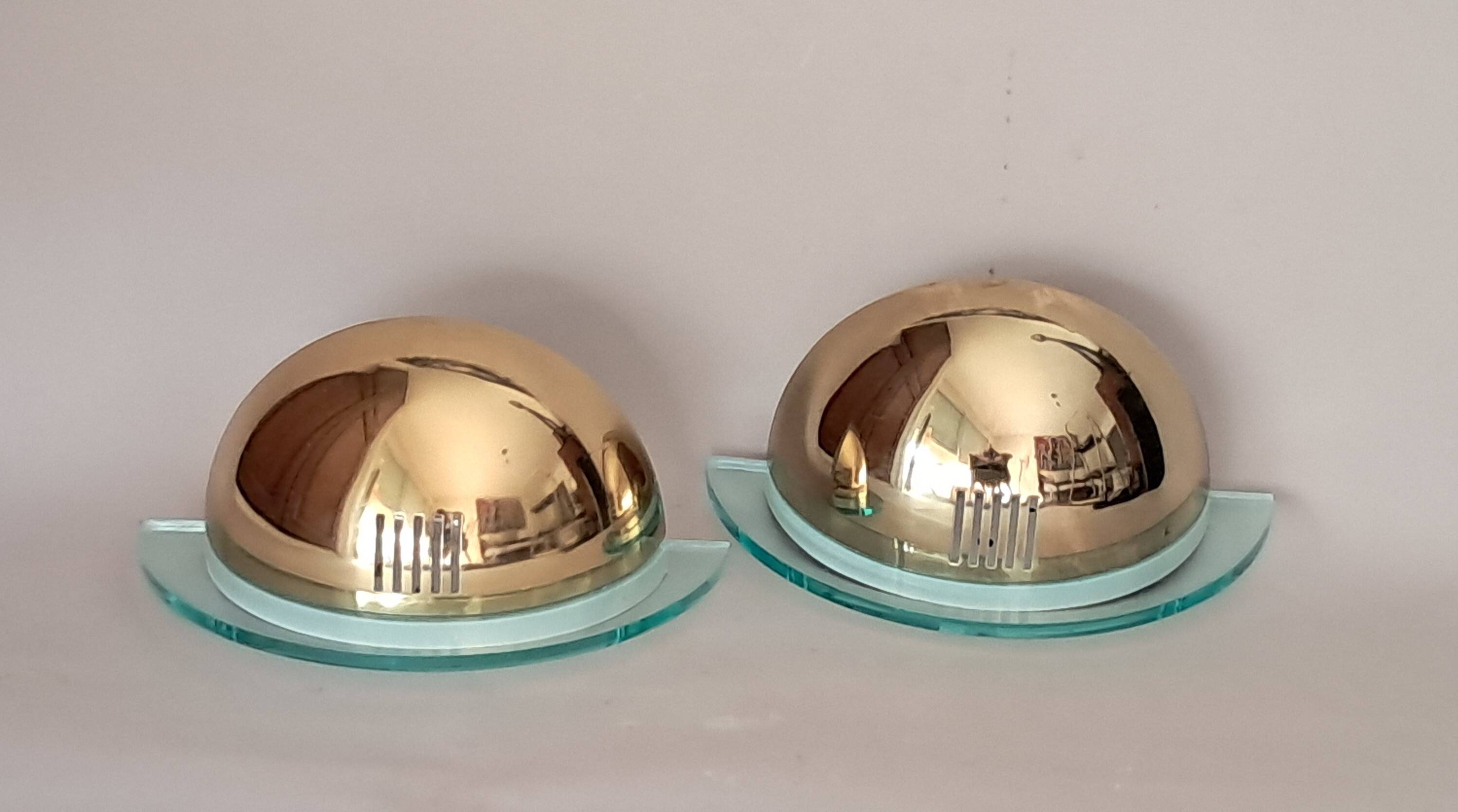 Pair of gold metal and plexiglass wall lights, circa 1980.
