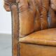 Antique, characteristic sheepskin chesterfield club chair on wheels