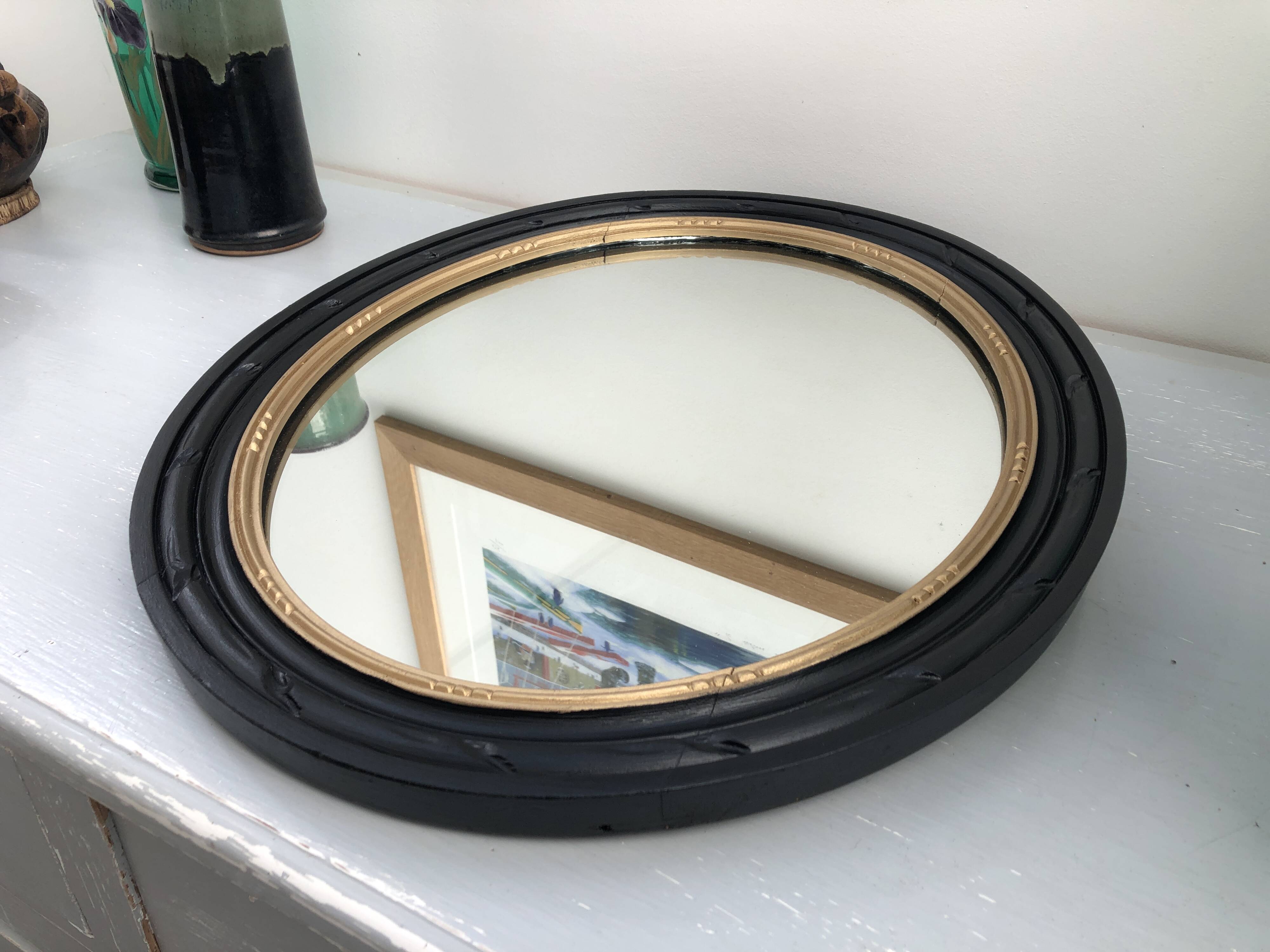 black and gold oval mirror