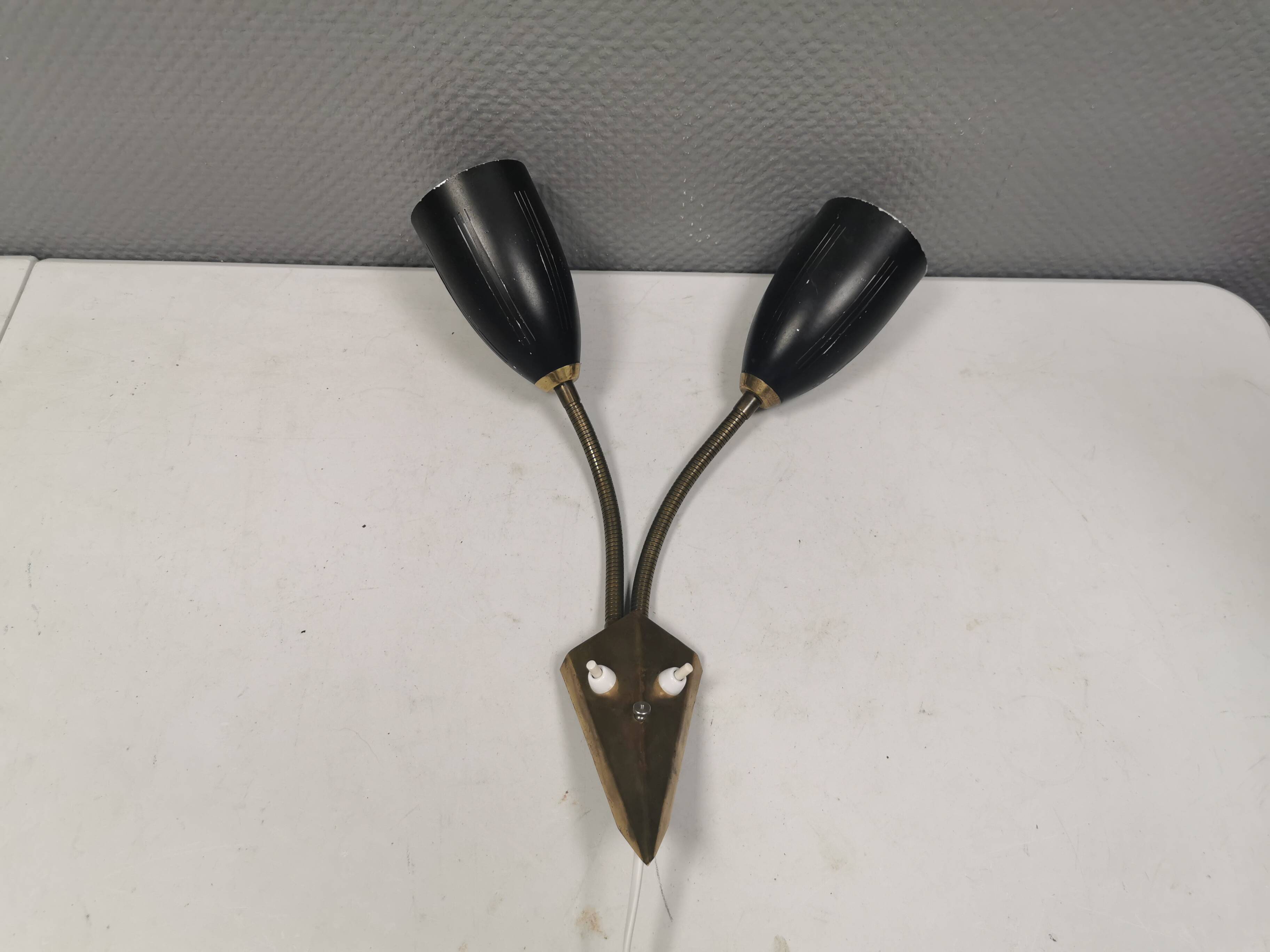 Older wall lamp with black metal shades and brass bend ‘arms’