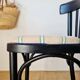 Curved black wooden bistro chair with striped seat