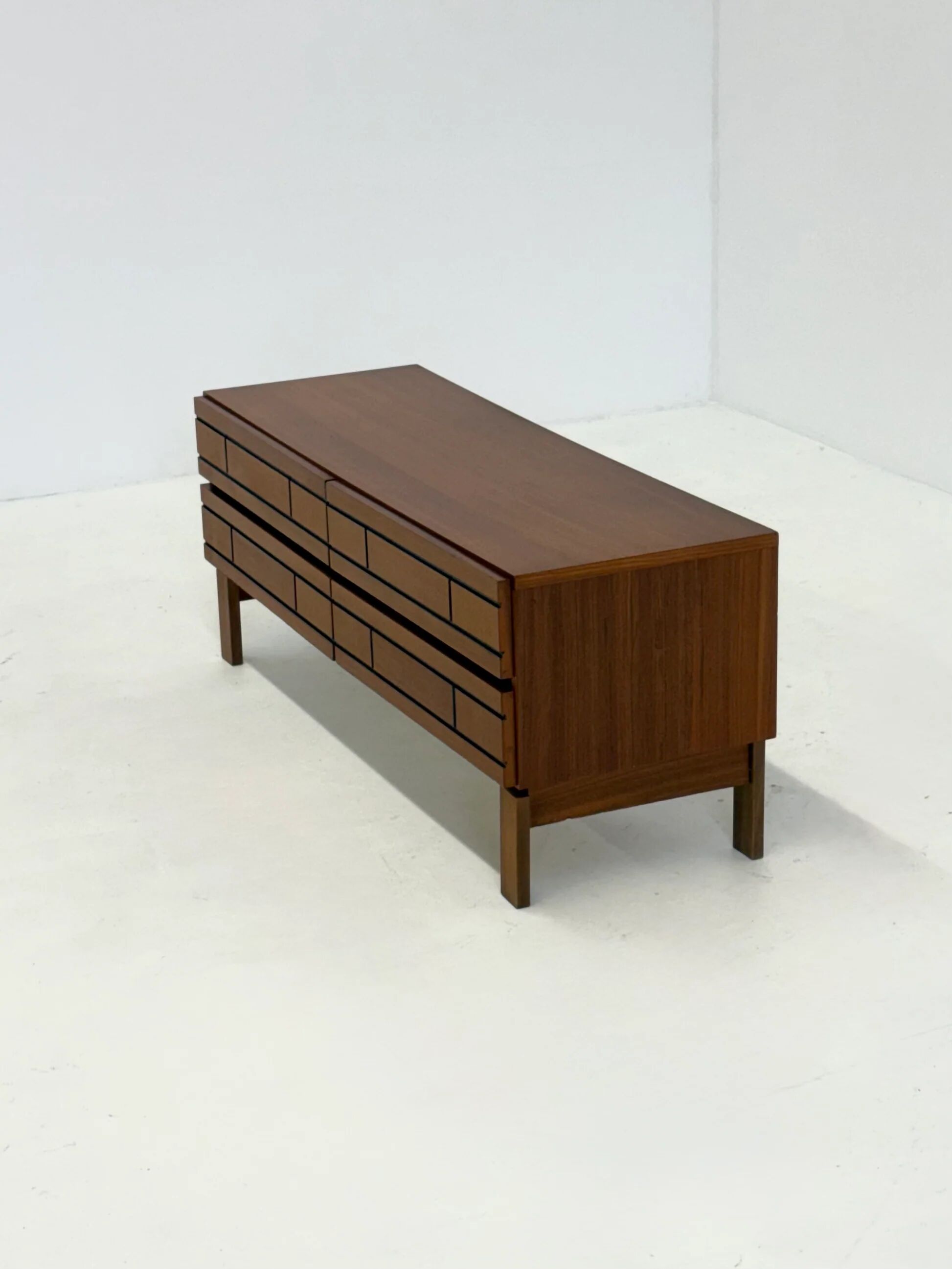 Buffet bas en bois italien avec des lignes noires graphiques.