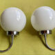 Pair of chrome metal wall lights with white glass globe.