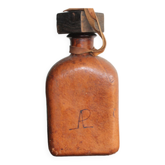 Old bottle covered in leather with its original wooden cap