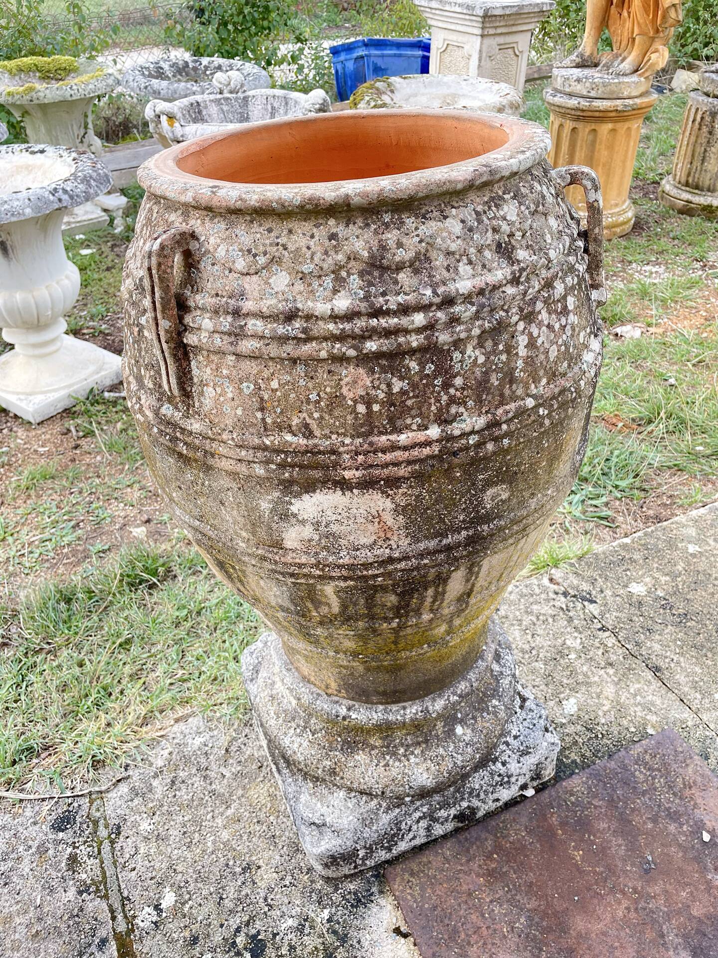 Large Cretan jar in terracotta with three handles on a stone base.
