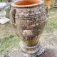 Large Cretan jar in terracotta with three handles on a stone base.