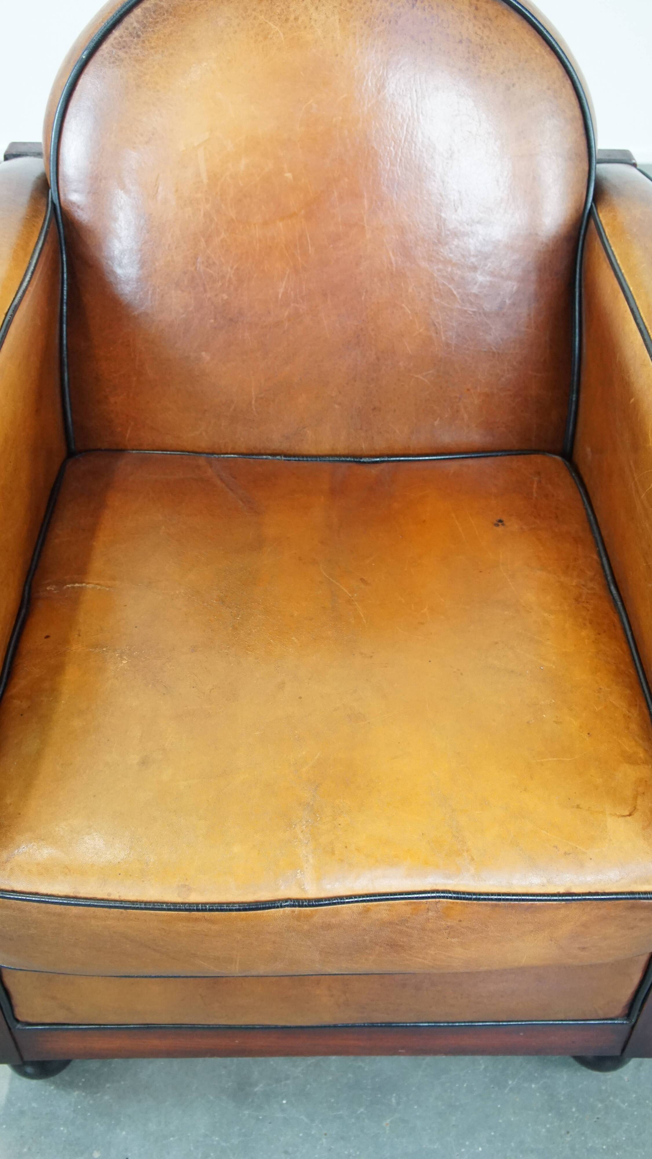Sheep leather and wooden Art Deco design armchair with ball feet