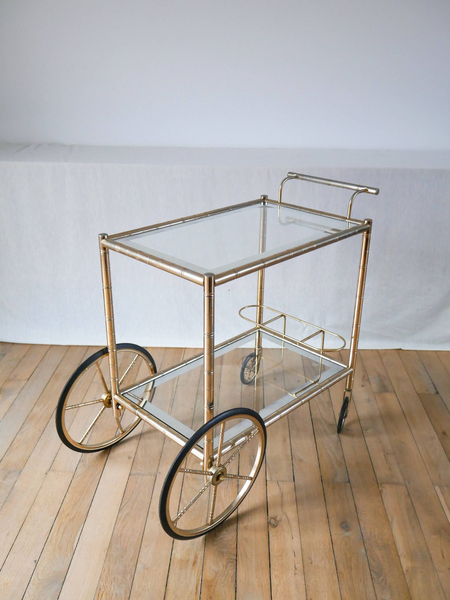 Desserte en métal doré et verre à grandes roues 1950