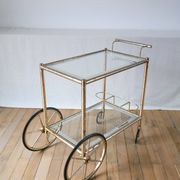 Desserte en métal doré et verre à grandes roues 1950