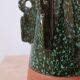 Sculptural ceramic vase with dark green glaze and shimmering highlights