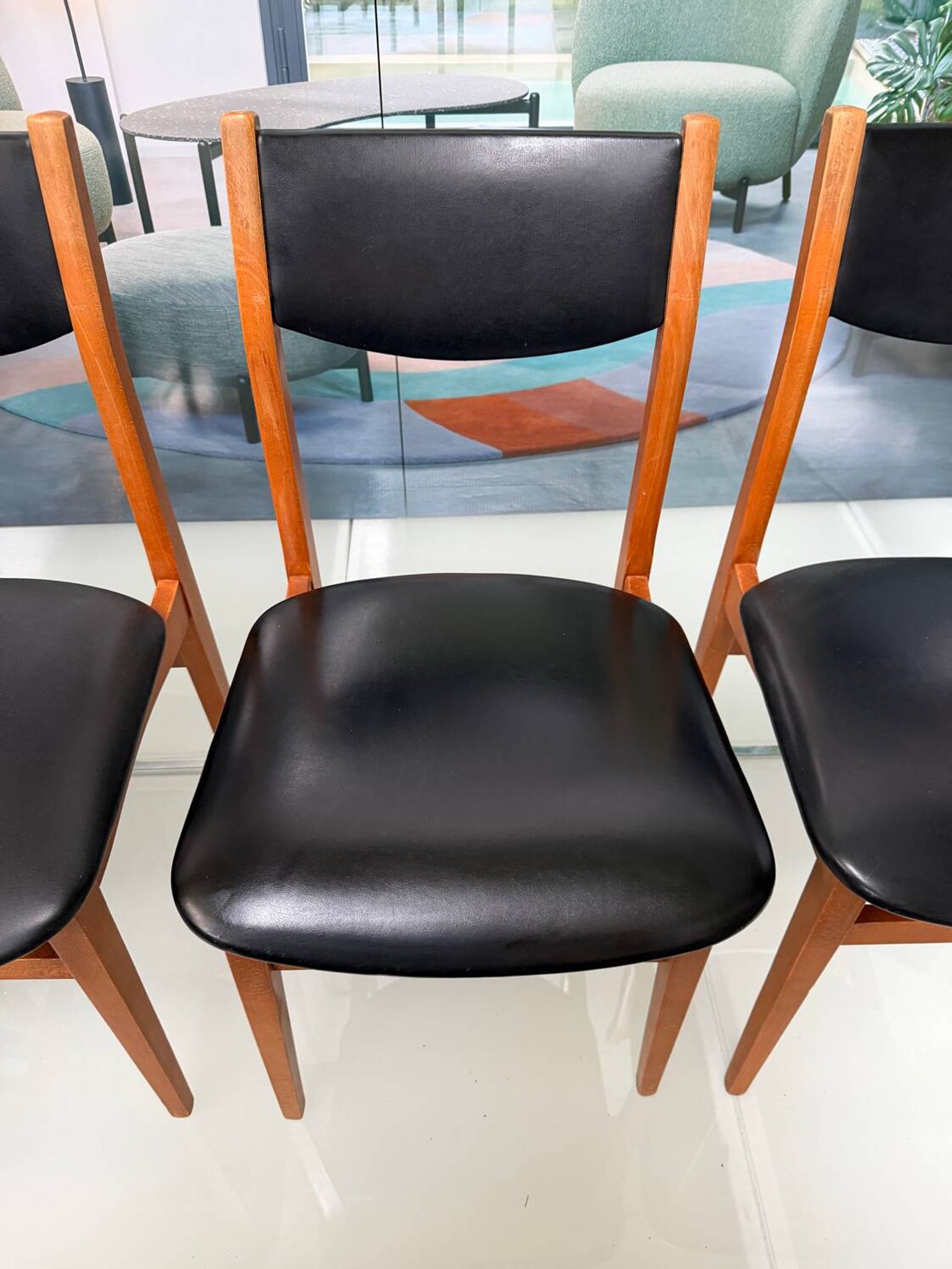 4 Scandinavian chairs in teak and black faux leather.
