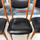 4 Scandinavian chairs in teak and black faux leather.
