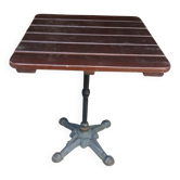 Bistro table with a cast iron base and a wooden top.