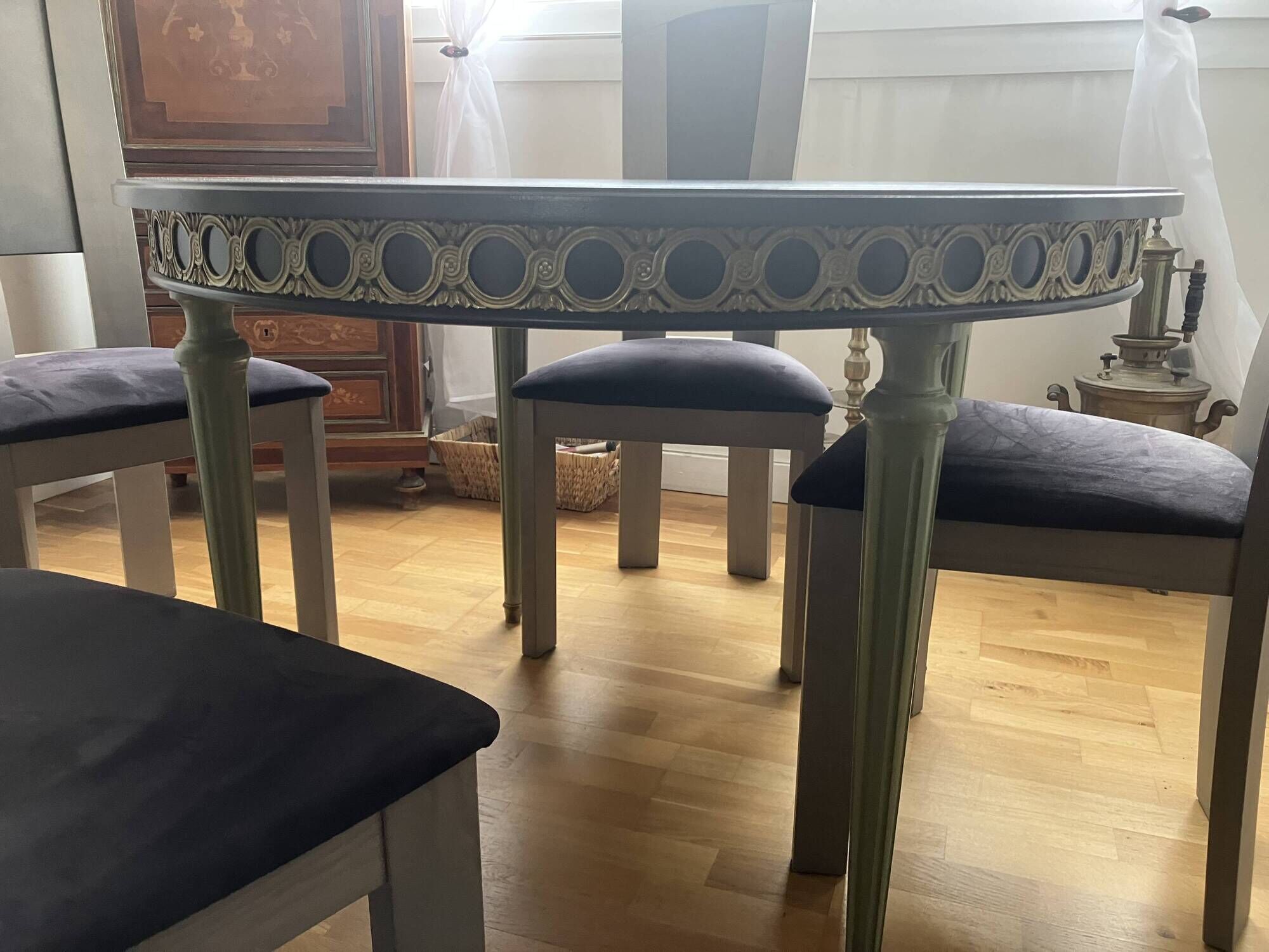 Extendable round table, 2 extensions, and 4 grey velvet chairs.