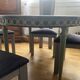 Extendable round table, 2 extensions, and 4 grey velvet chairs.