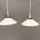 A set of hanging lamps in milky white opal glass with brass top.