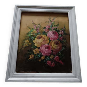 Old oil painting of a bouquet of roses in its frame.