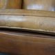 Old wingback armchair made of sheep leather in a correct condition