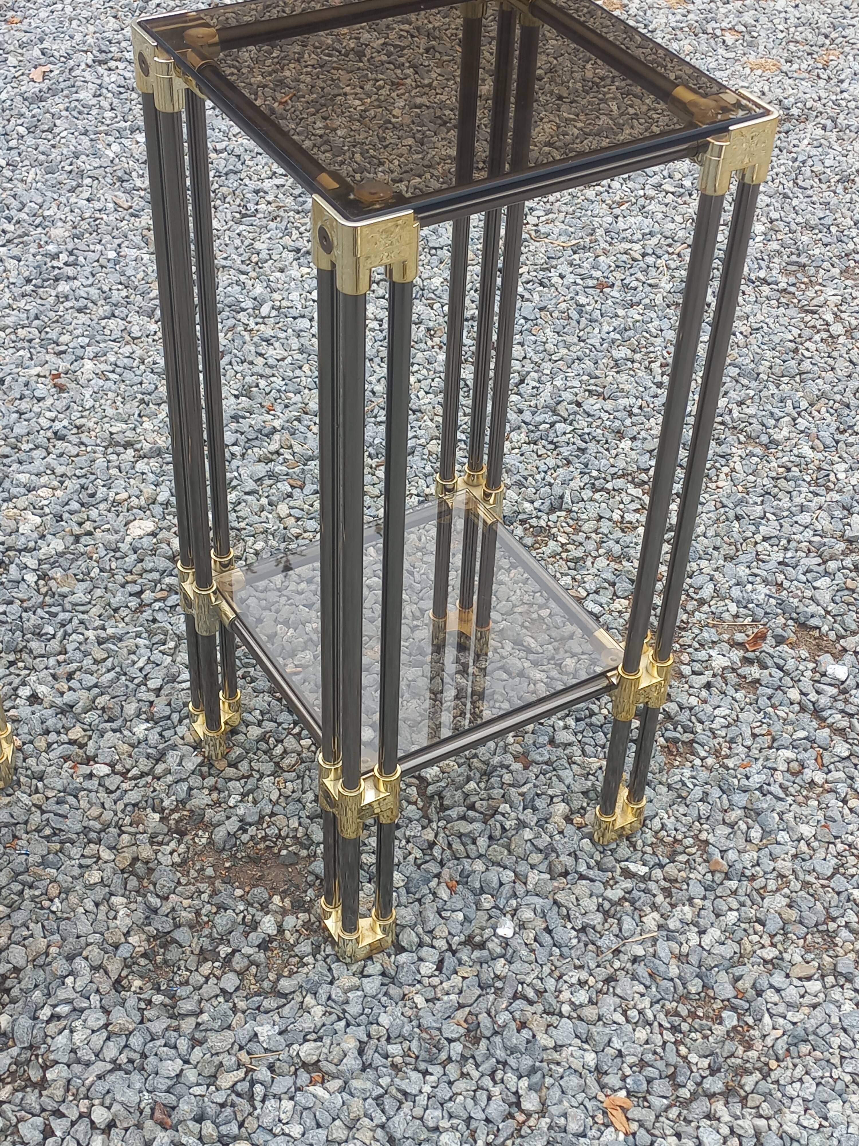 Pair of Hollywood Regency side tables in gold metal and smoked glass.