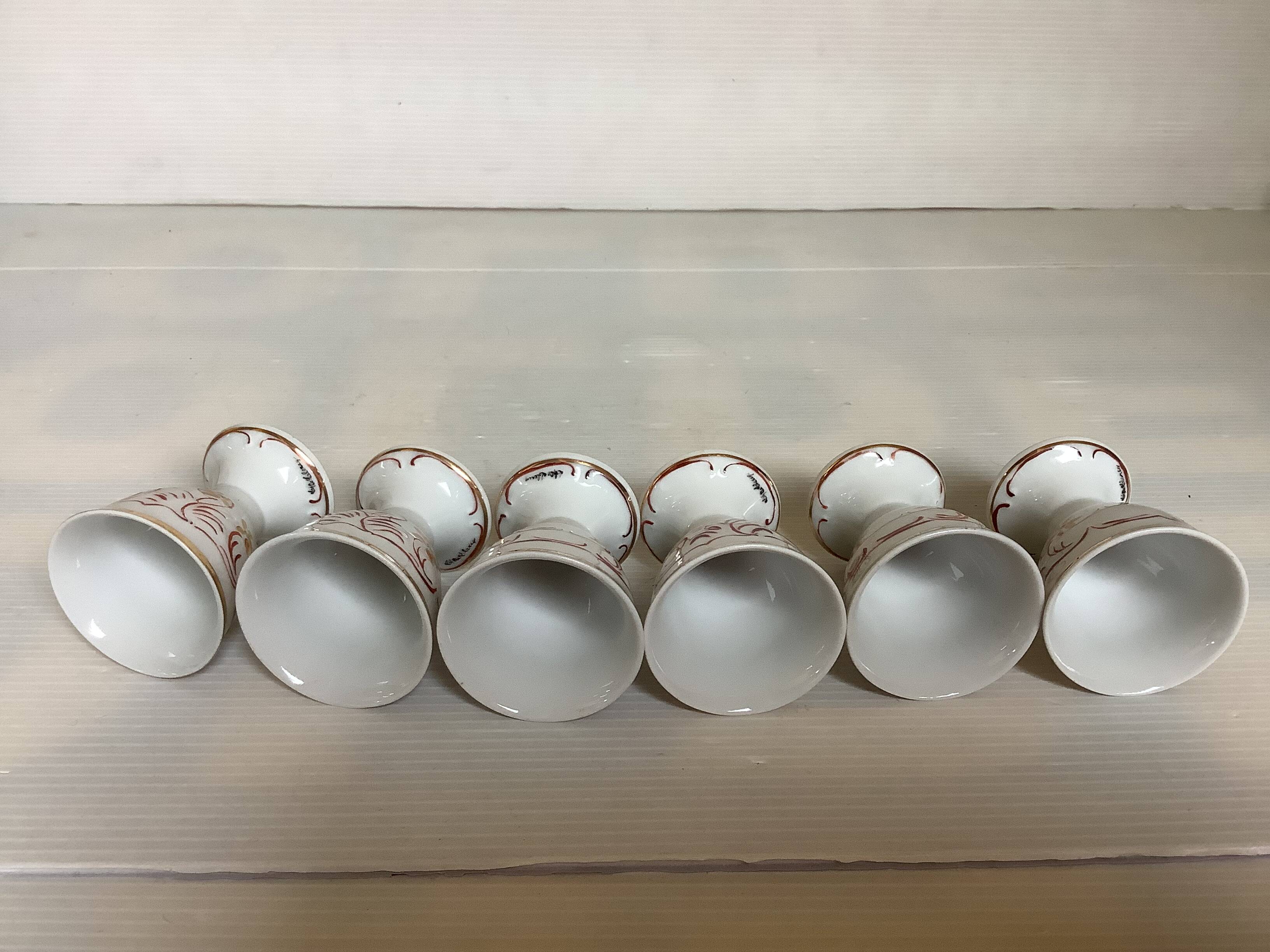 Six hand-decorated and signed egg cups