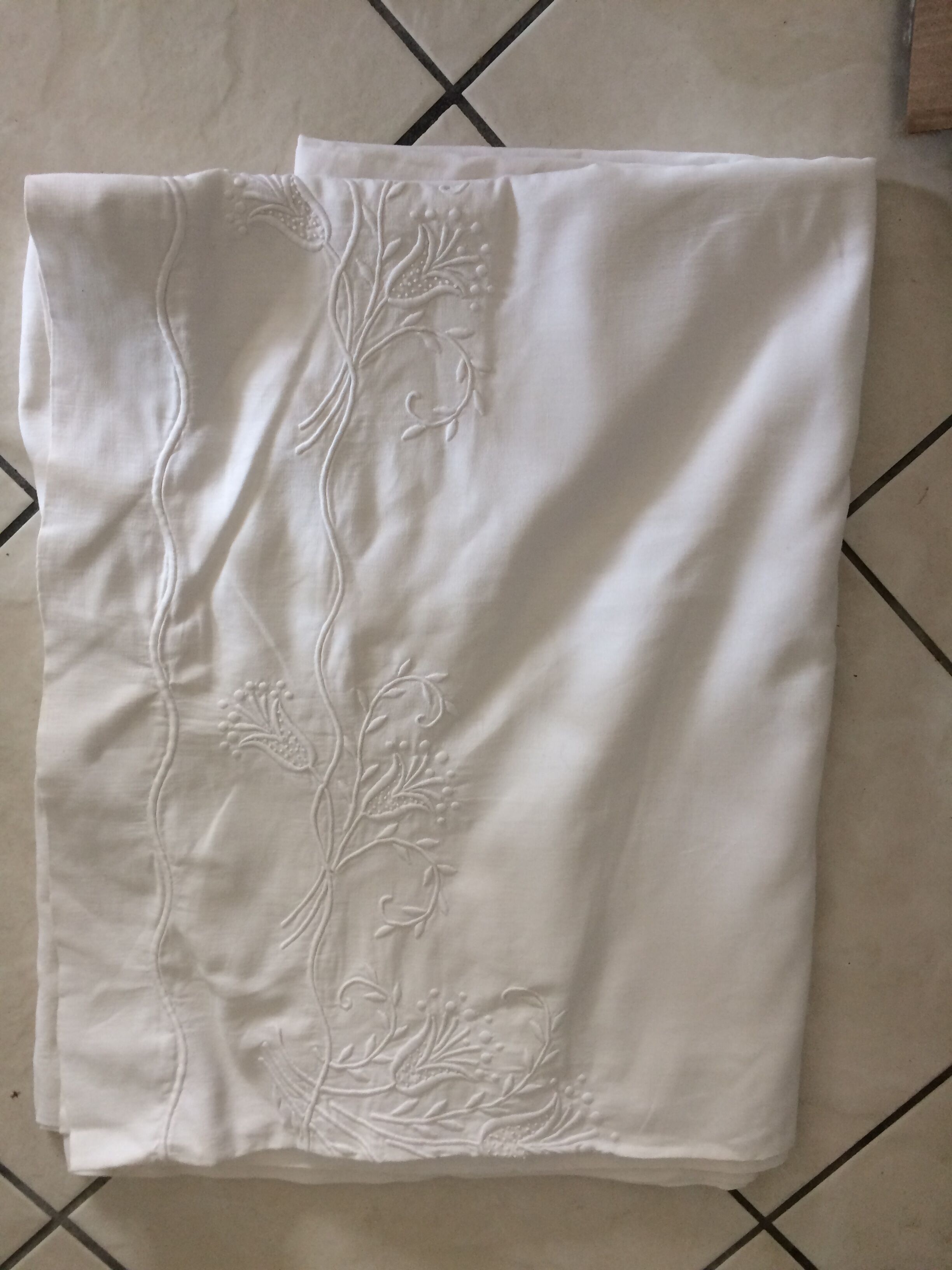 Old sheet with hand made embroidery, shaped flowers.