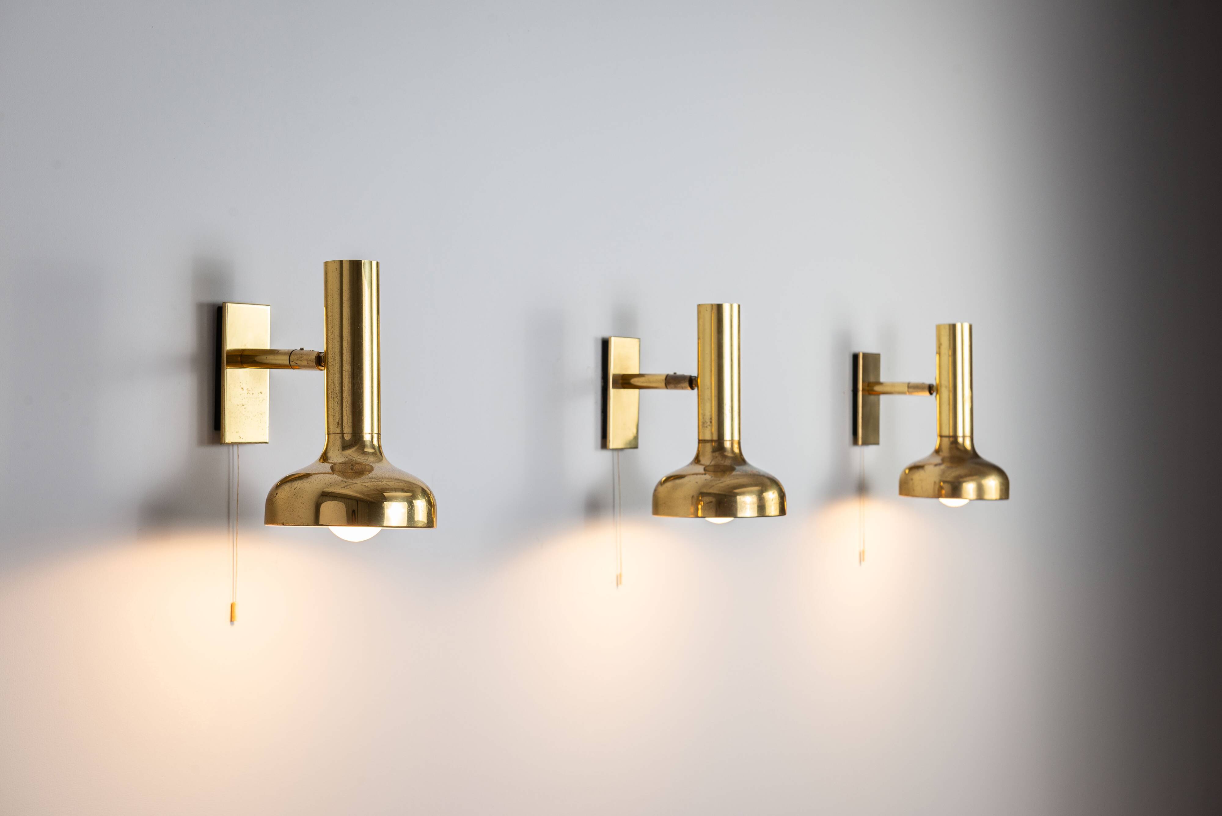 Set of three brass adjustable wall lamps
