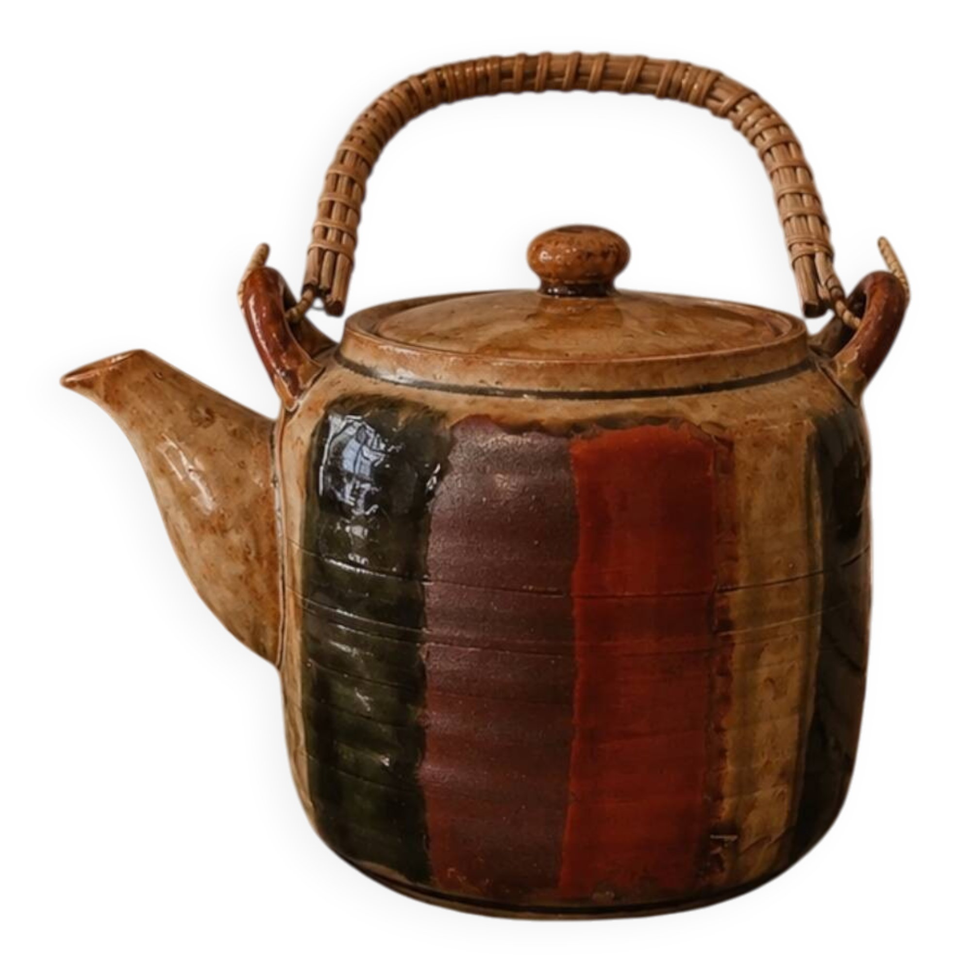 Vintage ceramic teapot with an enamel finish, rattan handle, warm tones.