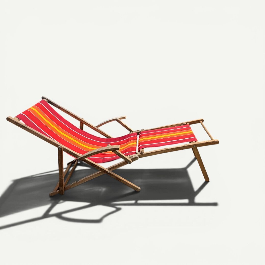 Vintage deck chair with red and orange striped fabric, original patina.