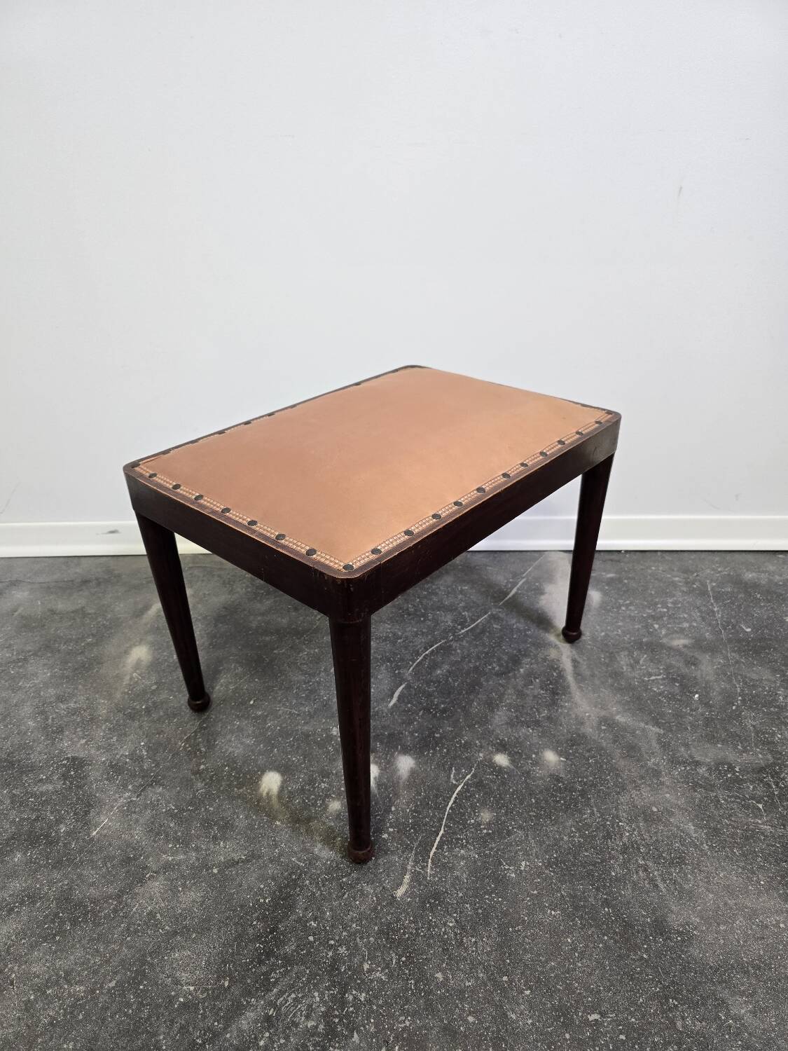 Vintage wooden ottoman from the 1940s with a silk top and studded trim.