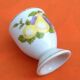 White porcelain egg cup decorated with pears / grapes.