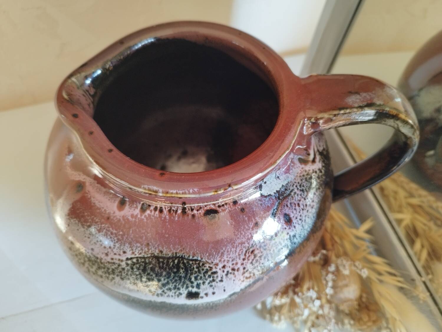 Stoneware pitcher by Matthieu Liévois in shades of red