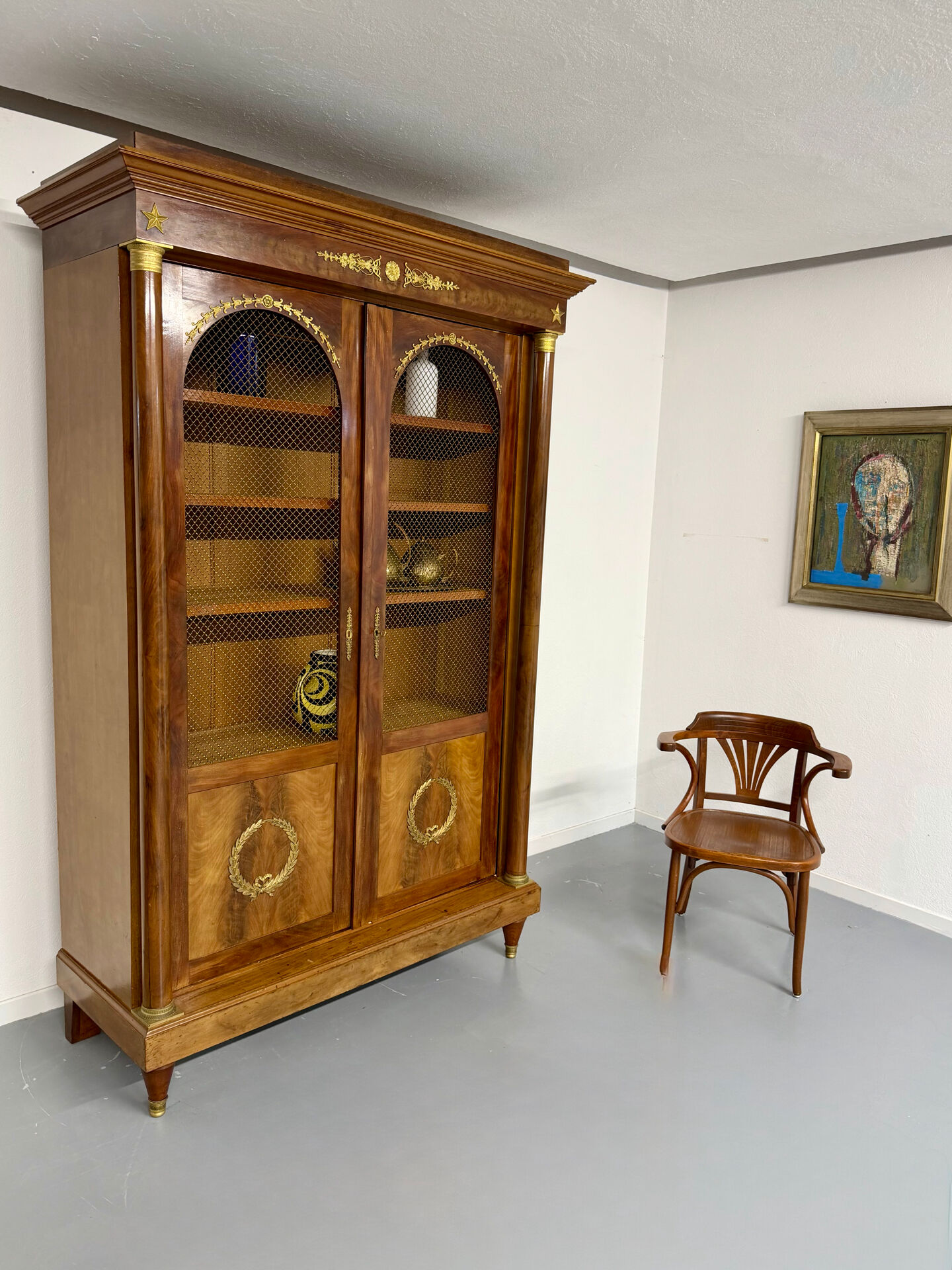 Large Empire-style library in wood with gilded bronze ornaments.