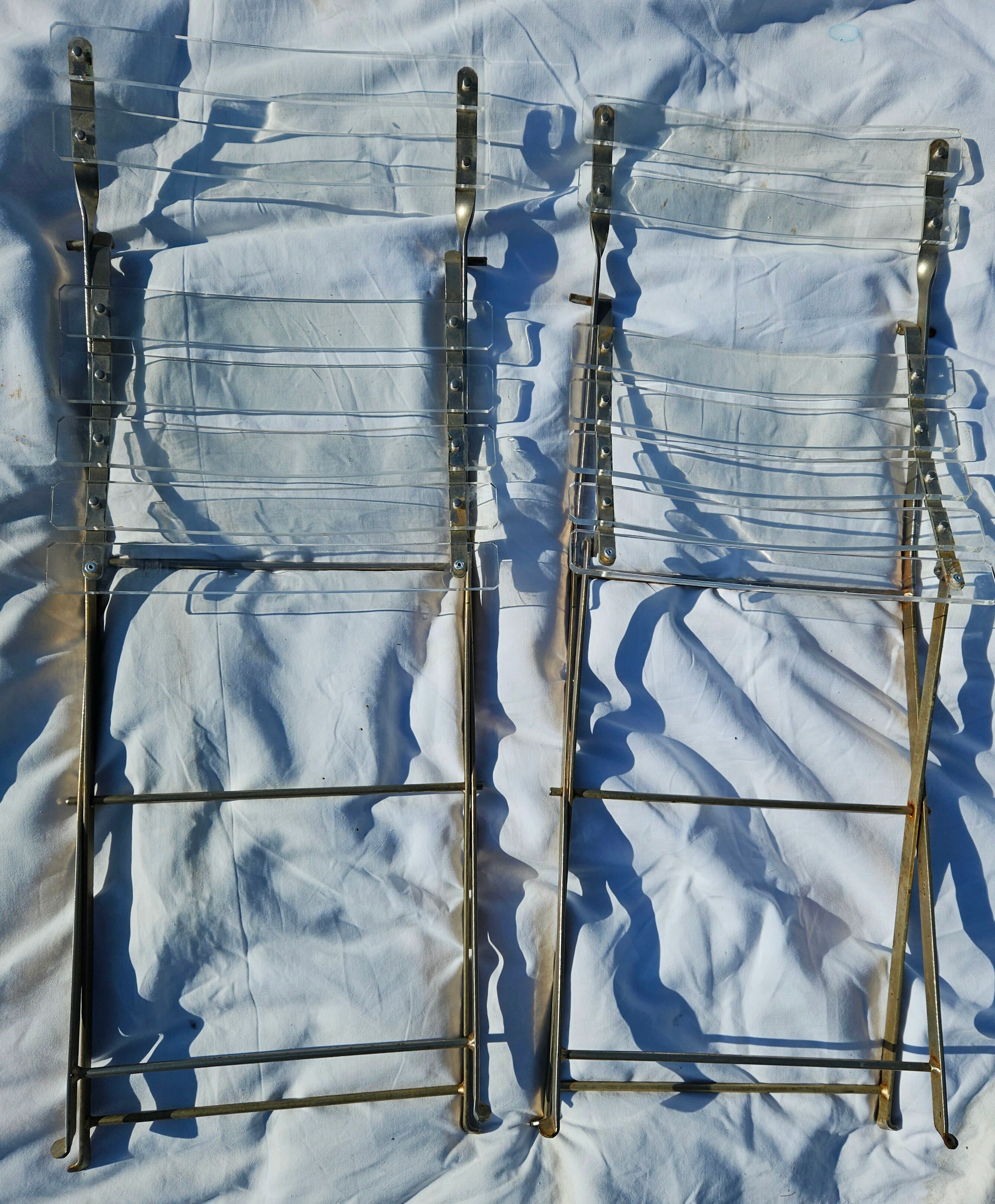 2 invisible folding chairs in metal and transparent plexiglass