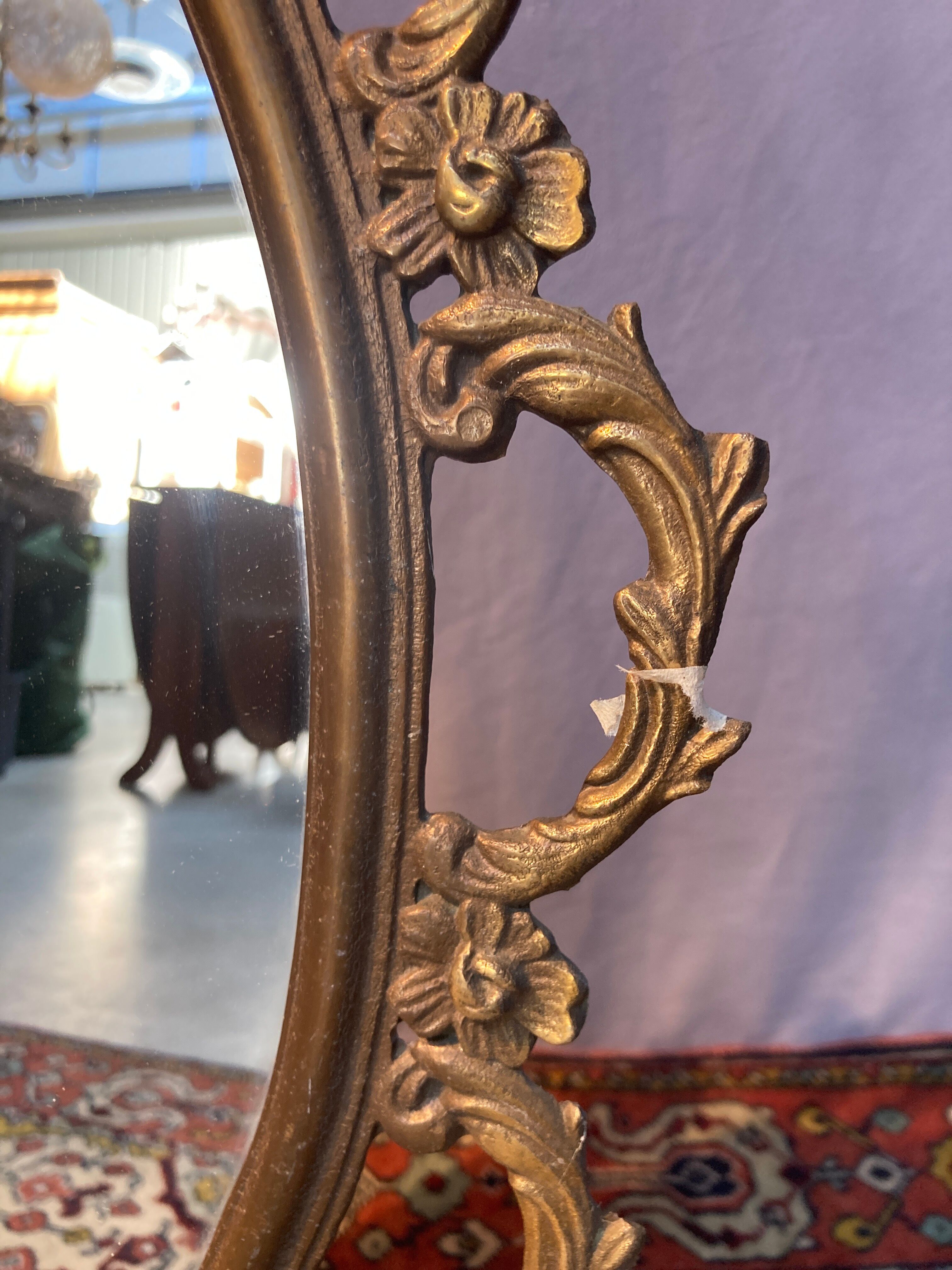 Oval mirror in gilded brass, figures of cherubs and moldings