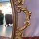 Oval mirror in gilded brass, figures of cherubs and moldings