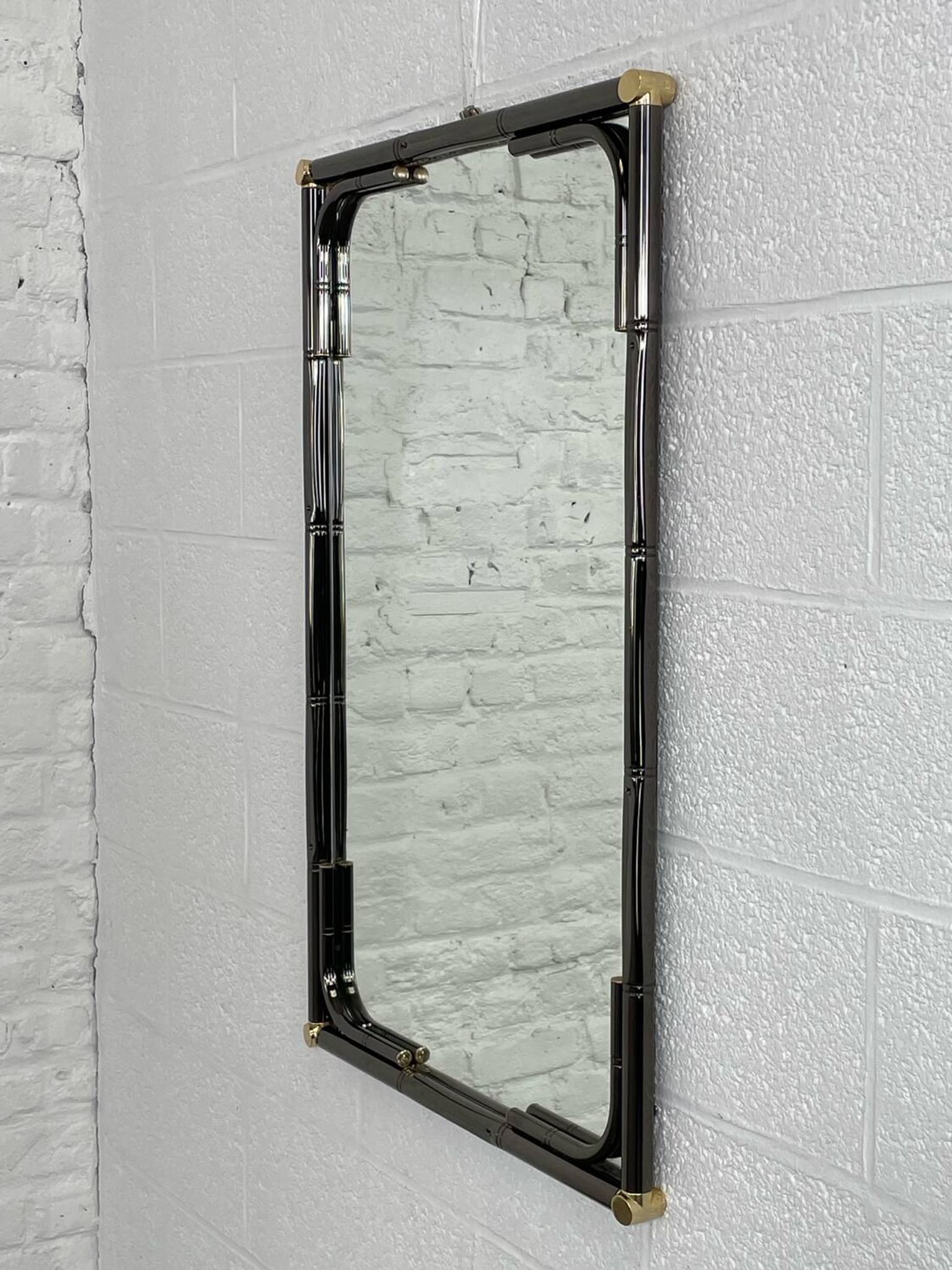 Mirror in black metal and brass with gunmetal finish