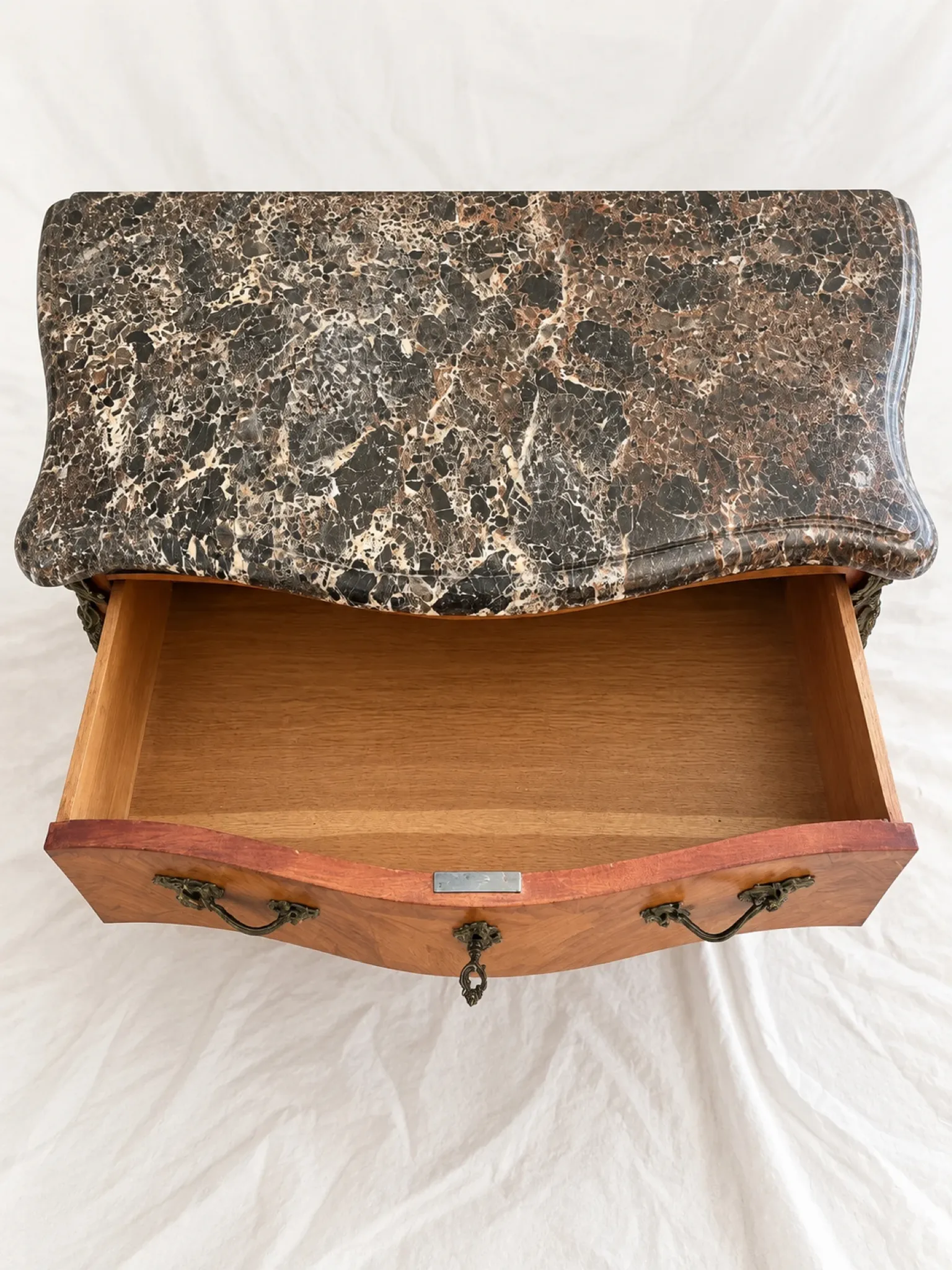 Curved Louis XV style commode in marquetry, veined marble and ornamentation.