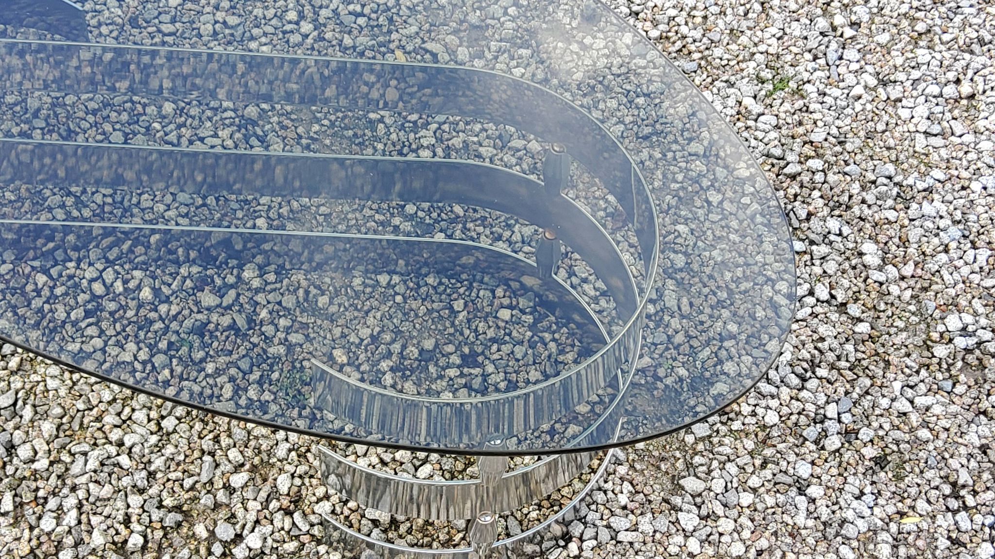 Oval coffee table of the 70s chromed metal base in s smoked glass top